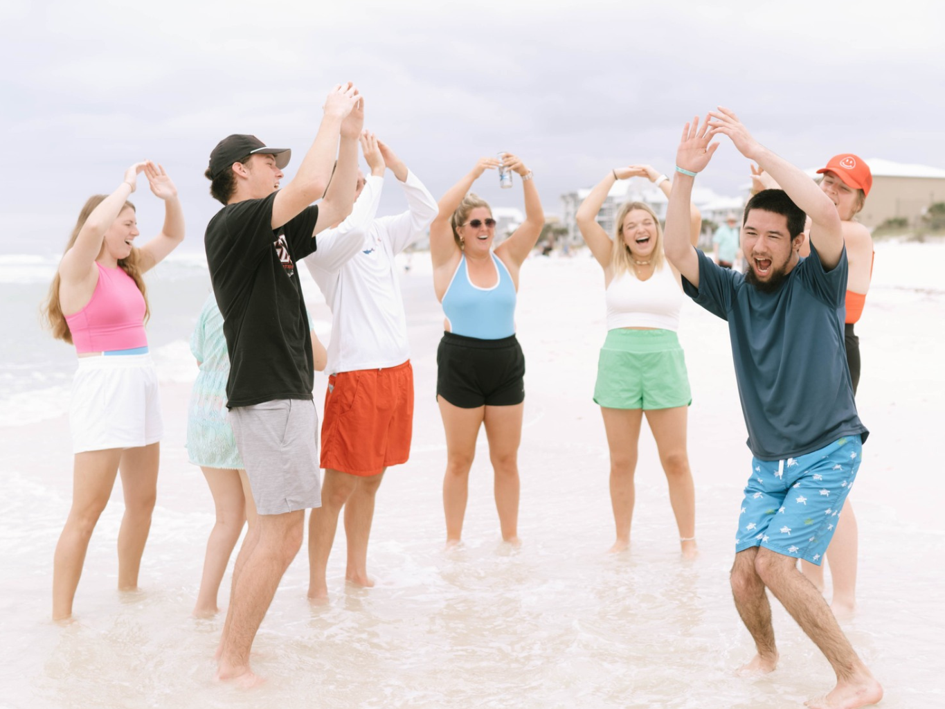 a group of people standing in water with their hands up