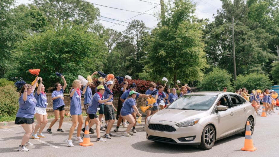 a group of people in blue shirts holding pom poms