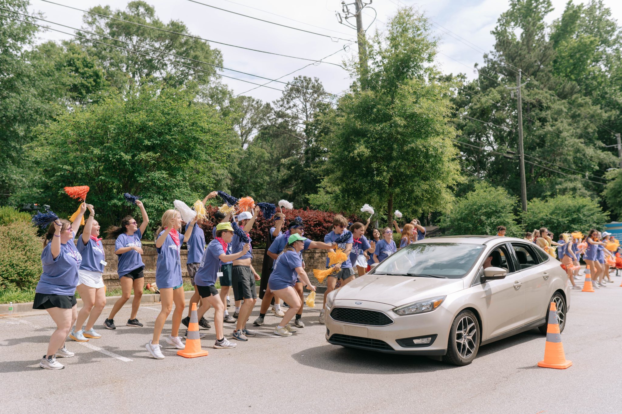 a group of people in blue shirts holding pom poms