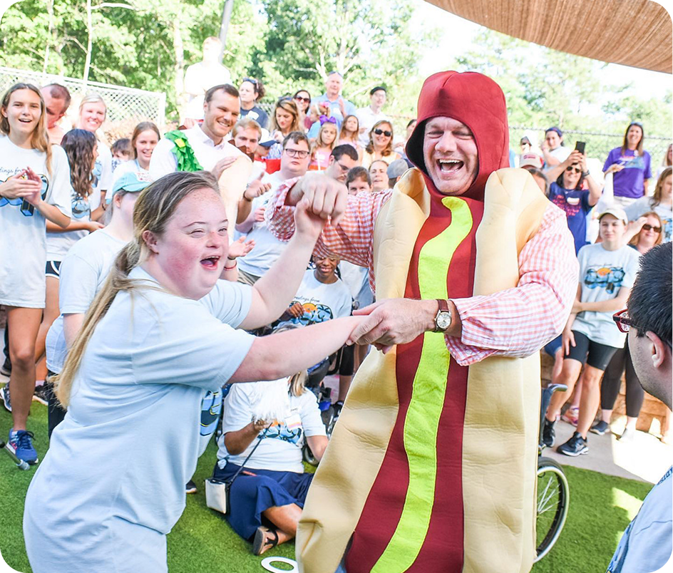 People playing while a man in a hot dog costume stands nearby